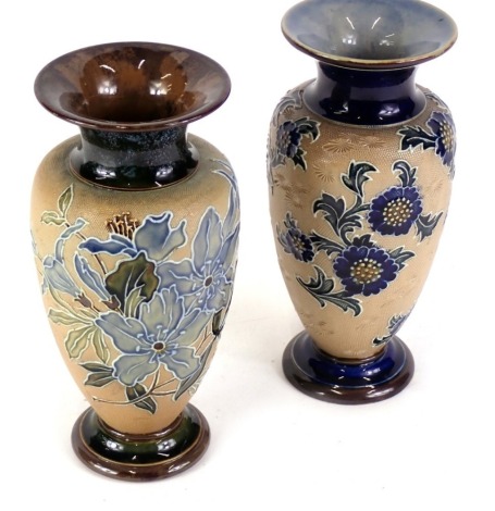 Two similar Royal Doulton stoneware vases, each decorated with flowers and leaves, within tube lined borders, on a beige ground, impressed marks to underside, 20cm high.