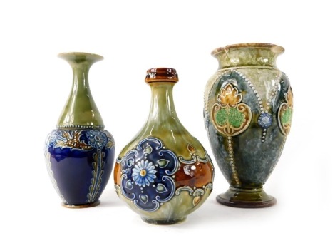 Three items of Doulton Lambeth stoneware, comprising an Art Nouveau style green and blue crested vase, 17cm high, stem vase, 15cm high, and a vase, 11cm high. (3, AF)