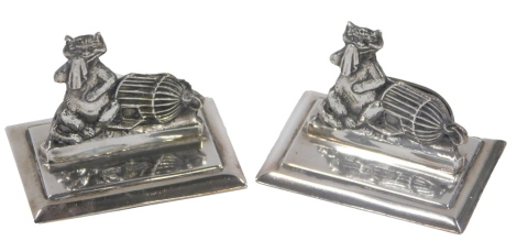 A pair of George V silver menu holder, each depicting novelty cat with cage and handkerchief, maker H&S, Birmingham 1910, 1.04oz.