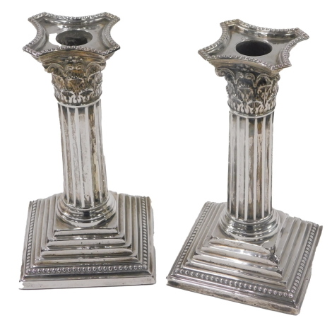 A pair of George V silver candlesticks, each of tapered and columned form, on weighted bases, Sheffield 1938, 17cm high.