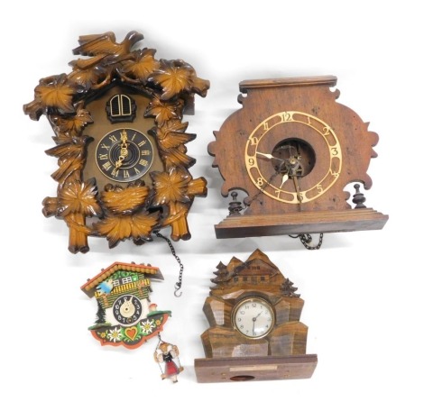 A Black Forest style cuckoo clock, another cuckoo clock, a Vienna wall clock, and a Swiss mantel clock, carved with chalet, fir trees, etc. (4)