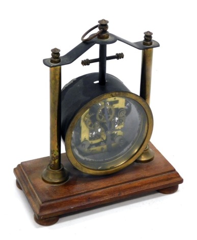 An early 20thC brass skeleton type clock, with brass supports and a mahogany vase, 25cm high. (AF)