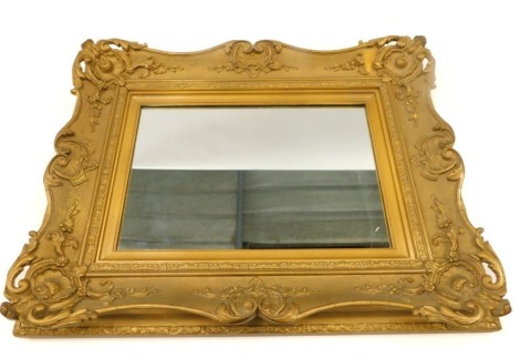 A gilt gesso rectangular wall mirror, the moulded frame decorated with shell, scrolls, etc., 73cm high, 56cm wide.