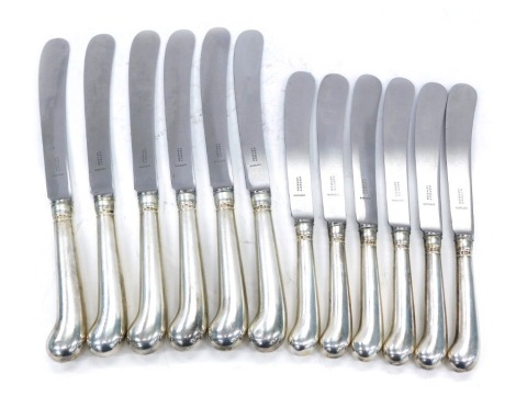 A set of six Asprey and Co Elizabeth II silver pistol handled table knives, each stamped to the blade Asprey London Rustless, London 1953, and a matching set of six dessert knives. (12)