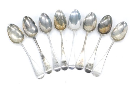 An associated set of eight Georgian silver old English pattern table spoons, all engraved to include a set of five engraved with one crest, three others with a differing crest, 16.2oz.