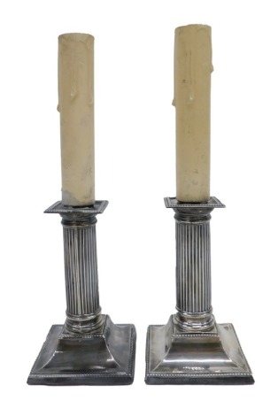 A pair of late Victorian silver candlesticks, each with a reeded column and a tapering base, loaded and converted to electricity, hallmarks to Sheffield 1894, the candlesticks 14cm high.