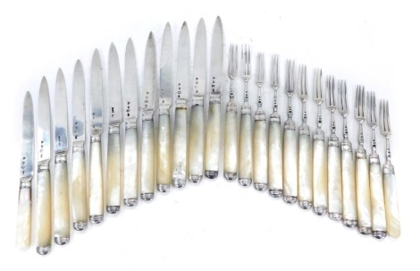 A set of twelve George IV dessert knives and forks, each with a silver blade, and a mother of pearl handle, the handle engraved with a castle crest, London 1821.