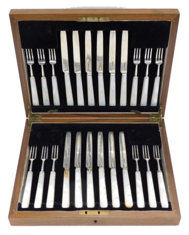 A set of twelve George V dessert knives and forks, each with a silver blade and mother of pearl handle, Sheffield 1934 (AF), in a fitted walnut canteen.