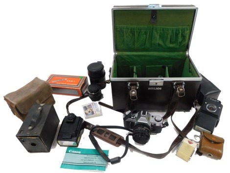 A Canon AE-3 camera, with extra lens, accessories, and a box camera.