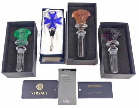 Three Rosenthal Versace glass decanter or bottle stoppers, each decorated with a mask, and a Maltese glass stopper, two boxed.