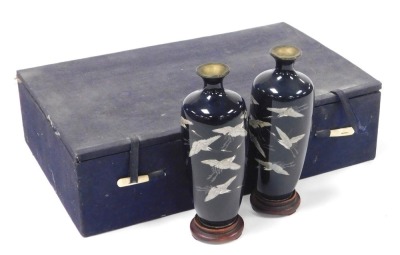 A pair of Japanese Meiji period silver wire cloisonne vases, on stands, of shouldered tapering form, decorated with birds on a dark blue ground, 15cm high.