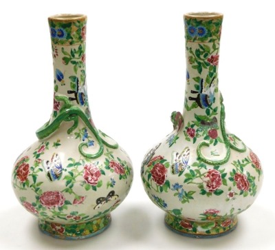 A pair of late 19thC Qing dynasty Cantonese famille rose pottery vases, of long necked bulbous form, moulded with chilin (baby dragons) and decorated with butterflies and flowers, 29cm high. - 2