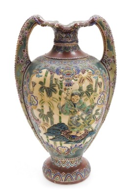 A Japanese Satsuma twin handled vase, decorated to the obverse in bas-relief with a figure in a boat, amongst bamboo, verso a reserve with flowers, Japanese numeral to the base, 43cm high.