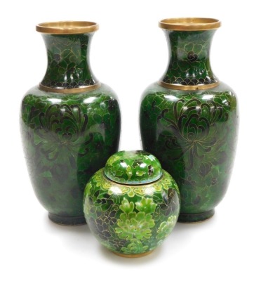 A pair of Chinese green cloisonne enamel vases, decorated with flowers, 21cm high, and a similar ginger jar and cover, 9.5cm high. (3)