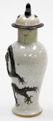 A 19thC Chinese crackle glaze vase and cover, of baluster form, decorated in relief with two Imperial dragons chasing a flaming pearl, the lid with lion dog finial, four character mark, 29cm high. (AF) - 2