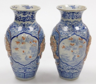 A pair of Meiji period Japanese blue and white vases, of shouldered, tapering form, decorated with reserve panels of relief decorated with shishi, interspersed with panels of birds and trees, on a blue and white floral and foliate ground, three character - 2