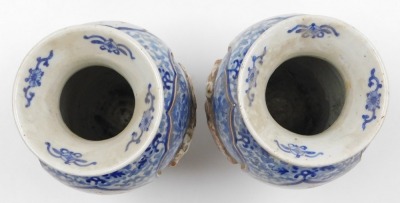 A pair of Meiji period Japanese blue and white vases, of shouldered, tapering form, decorated with reserve panels of relief decorated with shishi, interspersed with panels of birds and trees, on a blue and white floral and foliate ground, three character - 5