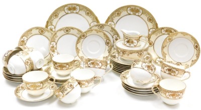 An early 20thC Noritake porcelain tea service, gilt decorated with flowers and foliate scrolls, on a pale yellow ground, comprising a pair of bread plates, cream, sugar bowl, twelve teacups, saucers, and tea plates.