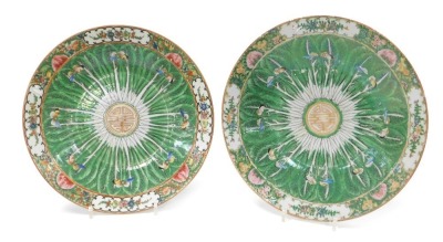 A pair of 20thC Chinese porcelain dishes, decorated centrally with bok choi, and butterflies, within a border with floral reserves, further flowers and fruit, on a gold ground, 30cm wide.