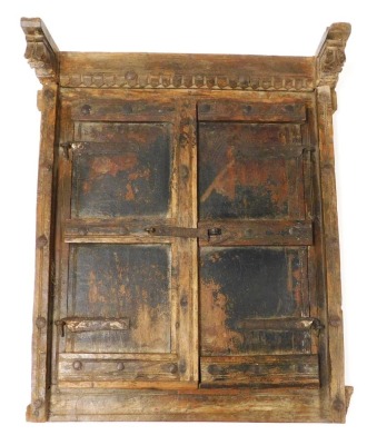 A 19thC Indian carved wood window shutter, with two doors, lock and hinges, 54cm x 45cm.