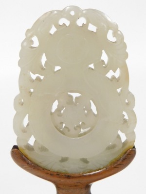 Three Chinese carved jade bi discs, one circular carved with a parrot and flowers, 5cm wide, another with flowers and leaves, 6cm wide, and an oblong disc decorated with a vase, framed by birds, 4.5cm wide, all on wooden stands. - 4