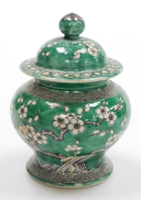 A Quing dynasty porcelain vase and cover, of baluster form, decorated with prunus blossom on a green ground, bears four character Kang-Hsi mark, 15cm high. (AF) - 3