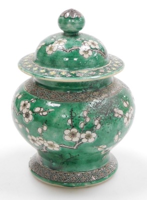 A Quing dynasty porcelain vase and cover, of baluster form, decorated with prunus blossom on a green ground, bears four character Kang-Hsi mark, 15cm high. (AF) - 4