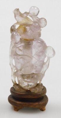 A Chinese quartz snuff bottle and stopper, carved with birds and berries, raised on a wooden stand, 8.5cm high. - 2