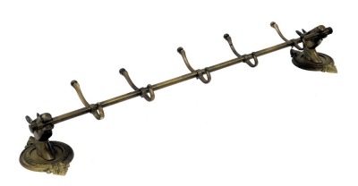 A brass wall hanging coat rack, the wall mounts formed as horse's head, on a circular and leaf cast backing, flanking five hooks, 102cm wide.