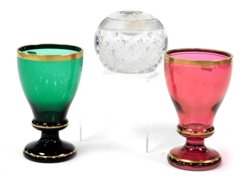 A Thomas Webb cut glass match striker, 9cm wide, together with two Bohemian cordial glasses, one in green, the other cranberry, gilt heightened, 14cm high. (3)