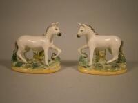 A pair of 19thC Staffordshire pottery figures of white horses