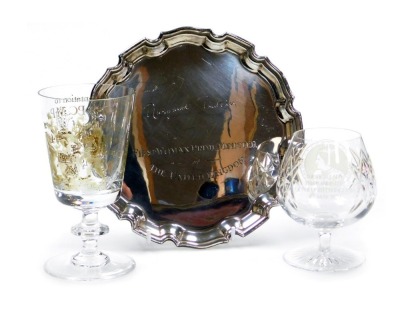 An EPNS salver, with piecrust border, engraved Margaret Thatcher First Women Prime Minister of Great Britain, and two glasses, one brandy cut glass inscribed with The First Lady Prime Minister of the United Kingdom, and another taller crystal glass inscri