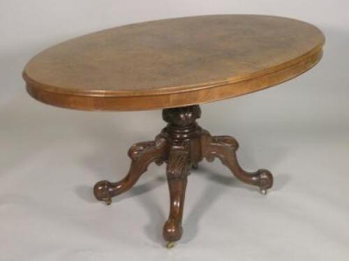 A Victorian burr walnut oval breakfast table on a leaf carved column with four downswept legs with b