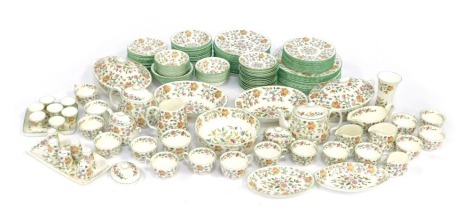 An extensive Minton tea and dinner service decorated in the Haddon Hall pattern, comprising twelve dinner plates, thirteen 9" plates, ten 8" plates, thirteen tea plates, fourteen 6.5" dessert bowls, twelve 5.5" dessert bowls, two oval tureens and covers, 