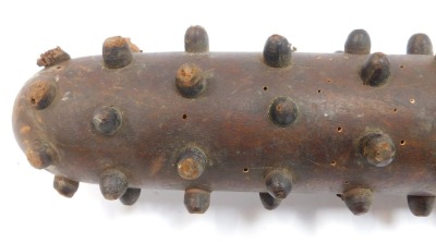 A World War One wooden trench club, the tapering handle joining a cylindrical club with various raised roundels, 80cm long. - 2