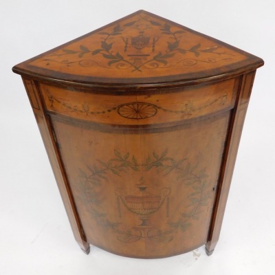 An Edwardian Neo Classical revival Edwards and Roberts mahogany and inlaid bow fronted corner cupboard, decorated to the door with an urn surrounded by leaves and fruit, on spade feet. - 2