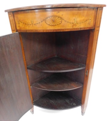 An Edwardian Neo Classical revival Edwards and Roberts mahogany and inlaid bow fronted corner cupboard, decorated to the door with an urn surrounded by leaves and fruit, on spade feet. - 3