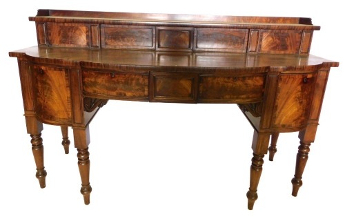 A George IV mahogany sideboard, the raised back with a gallery, above two sliding figured doors, the breakfront base with an arrangement of three frieze drawers, flanked by a cellarette drawer and a door, on turned tapering legs, 118cm high, 159cm wide, 8