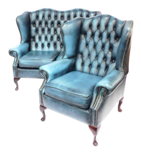 A Saxon button back wingback two seater sofa, with stud work, raised on four cabriole legs, with pad feet, 130cm wide, together with a matching wingback armchair.