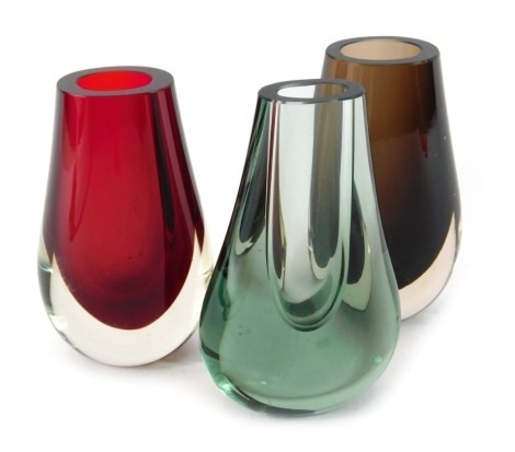 Three Whitefriars glass 'Teardrop/Hambone' vases, designed by Geoffrey Baxter, in sea green, cinnamon, and ruby red, pattern number 9572, 14.5cm and 13cm high.