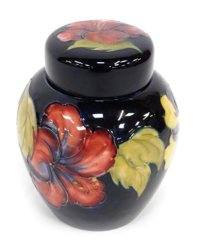 A Moorcroft pottery ginger jar and cover, decorated in the Hibiscus pattern, paper label and impressed marks to underside, 16cm high.