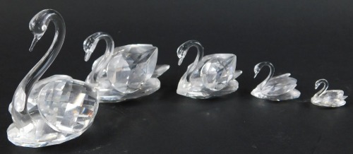 A set of four graduated Swarovski crystal swans, the largest 5.5cm high, together with a further cut glass swan.