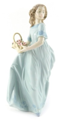 A Lladro porcelain figure, modelled as a lady holding flower basket, printed marks, 22cm high.