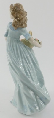 A Lladro porcelain figure, modelled as a lady holding flower basket, printed marks, 22cm high. - 2