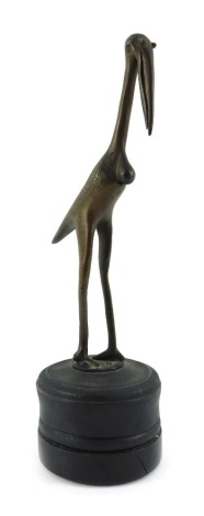 A 20thC bronze sculpture, modelled as a stork, with incised decoration, mounted on an ebonised cylindrical hardwood base, unsigned, 25.5cm high. (AF)