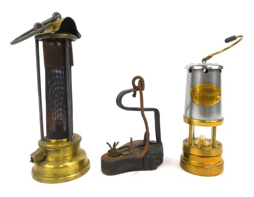 Mining interest. A miniature Ashington Collier reproduction miners lamp, 17cm high, a paraffin wick burner lamp, 14cm high, and a brass burner, 24cm high. (3)