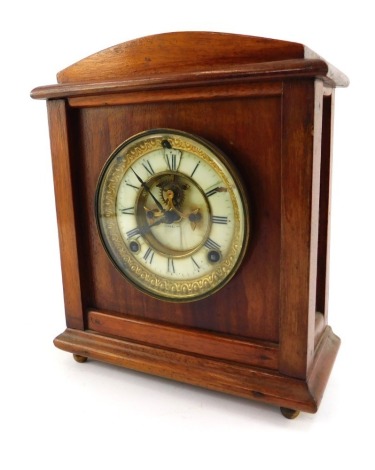 A late 19thC/early 20thC oak cased mantel clock, the circular enamel dial bearing Roman numerals, brass chapter ring, eight day movement, with key and pendulum, 27cm high.