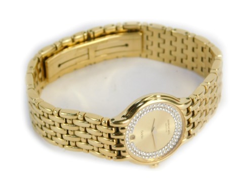 A Raymond Weil Fidelio 18ct gold electroplated lady's wristwatch, with small circular dial with double row of white imitation stones to border, and date aperture, on four bar bracelet, serial number 4702, stamped lugs 1189, the clasp stamped Acier Inox 18