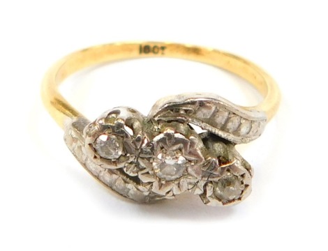 A diamond three stone twist ring, the central section set with three diamonds, in rub over setting, with twist shoulders, in platinum, on a yellow metal band stamped 18ct, size M, 3.1g all in.