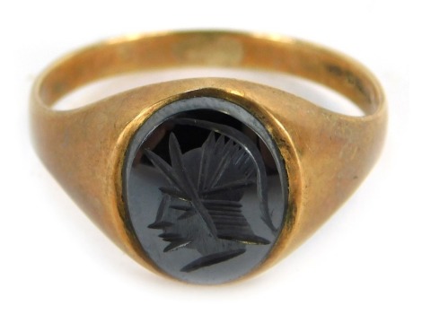 A 9ct gold signet ring, the oval cabachon set with black moon finish stone, engraved with a Centurian, size W½, 3.8g all in.